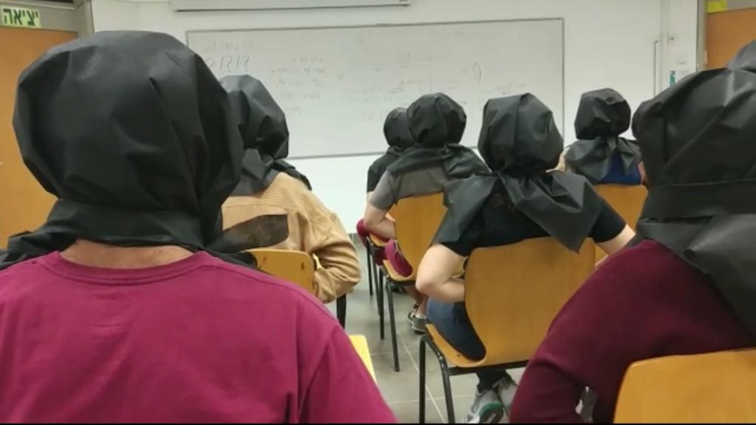 סטודנטים שראשם מכוסה בבד שחור בסרטון שהופץ. צילום מסך: כארם אבו גאנם